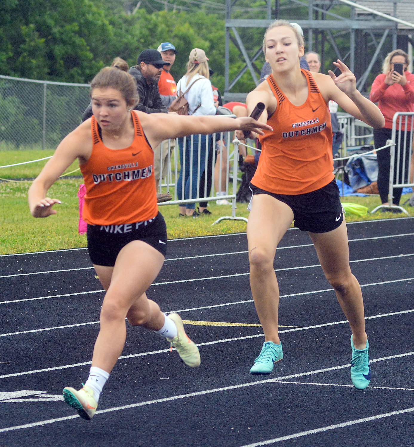 Alexis Kohrmann (far left) reaches back for the baton from Ella Gehlert during the girls 4x200-meter relay. Owensville went on to place third to advance to state in that event.